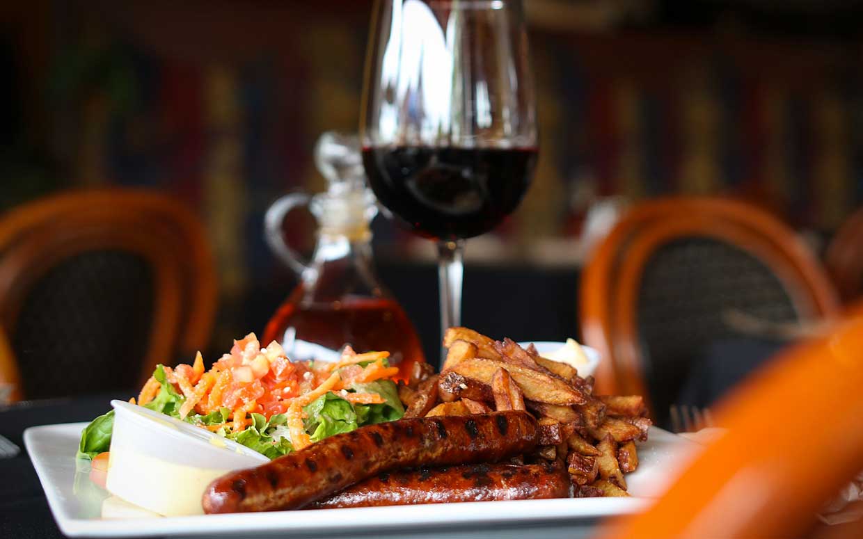 Saucisses Grillées avec frites, salade et verre de rouge